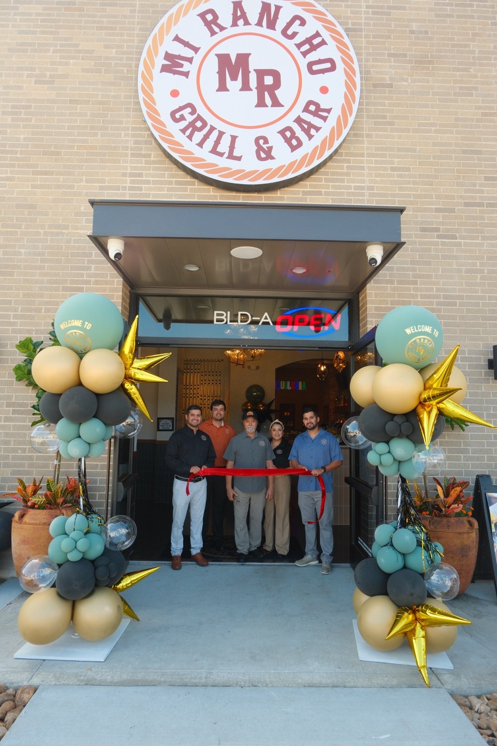 The Lozano family celebrating a Mi Rancho grand opening with a ribbon cutting
