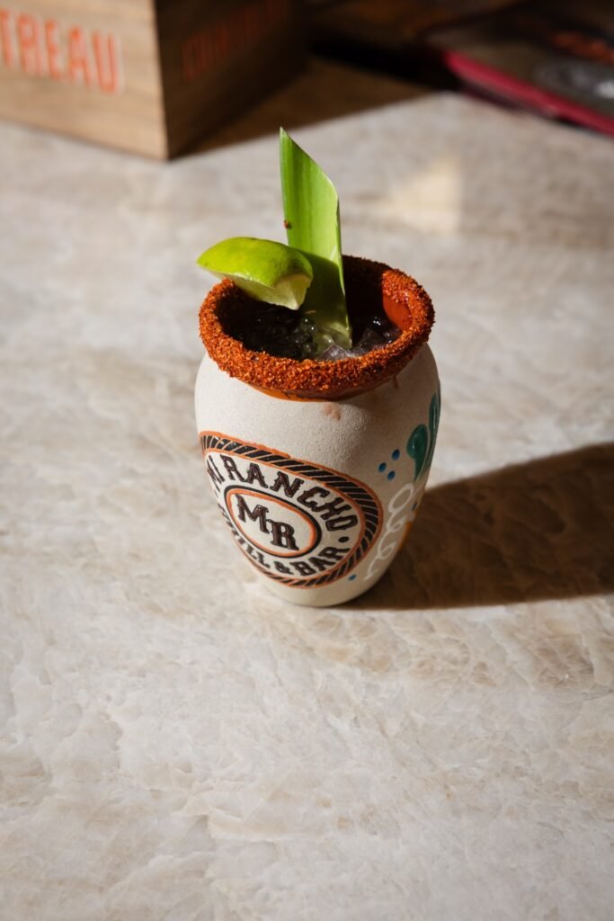 Paloma served in a Mi Rancho clay cup with a chile-salt rim and lime wedge